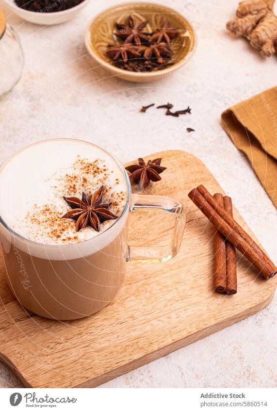 Leckerer Chai Latte mit Zimt und Sternanis Chai-Tee Gewürztee Latte Art Zimtstangen Ingwerwurzel Teeblätter Milchschaum gemütliches Getränk warmes Getränk