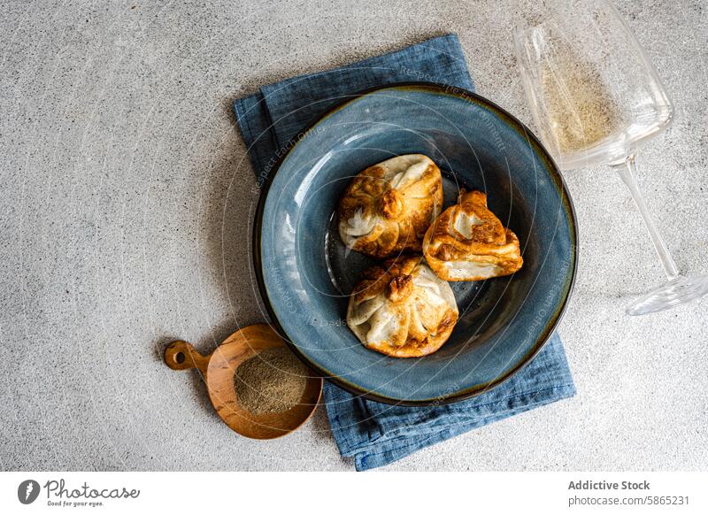 Goldgebräuntes Khinkali auf einem Keramikteller serviert georgisch Küche Knödel khinkali Teller blau rustikal Ästhetik kulinarisch traditionell