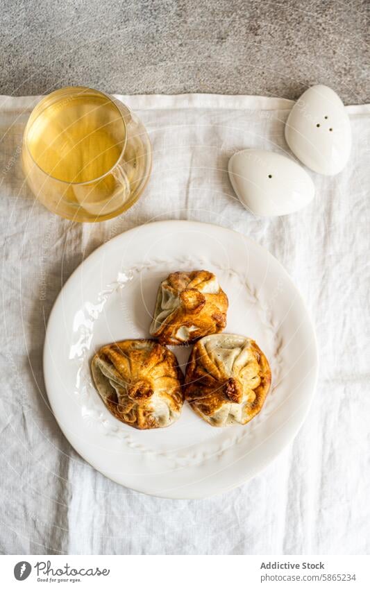 Traditionelles georgisches Khinkali auf einem weißen Teller mit Wein Küche khinkali Knödel traditionell weiße Platte Glas Weißwein rustikal Mahlzeit Speise