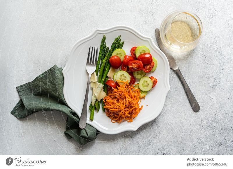 Frischer Gemüsesalat mit Spargel und geraspelter Karotte Salatbeilage Tomate Salatgurke Möhre Käse Teller Draufsicht frisch Gesundheit Mahlzeit Diät Veganer