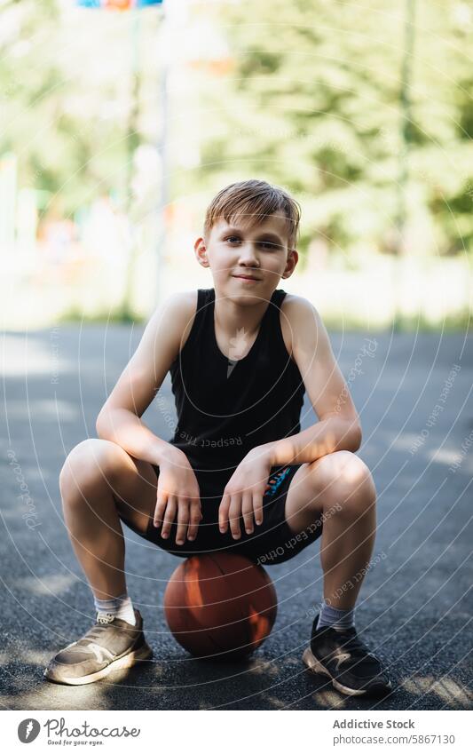 Teenager macht eine Pause vom Basketballspielen im Freien Sport aktiv jung männlich Park Sitzen fokussiert sportlich Fitness Jugend Erholung lässig Sommer