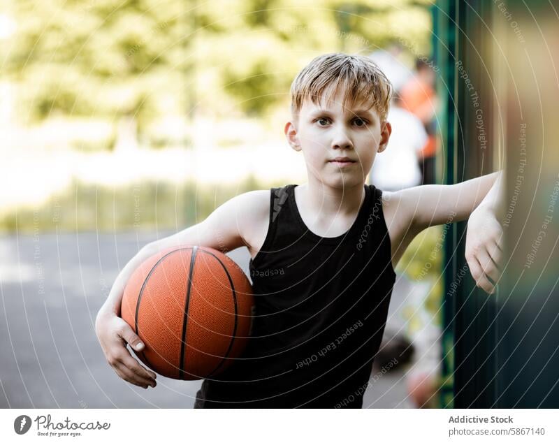 Junger Junge mit einem Basketball auf einem Platz im Freien an einem sonnigen Tag Teenager Gericht jung sportlich Spiel Sommer Jugend Athlet aktiv Erholung