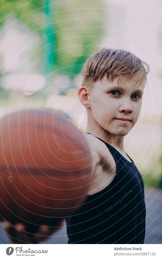 Teenager streckt einen Basketball in Richtung der Kamera Sport Ball Hand Fokus Fähigkeit Leidenschaft jung männlich im Freien Spiel spielen sportlich aktiv