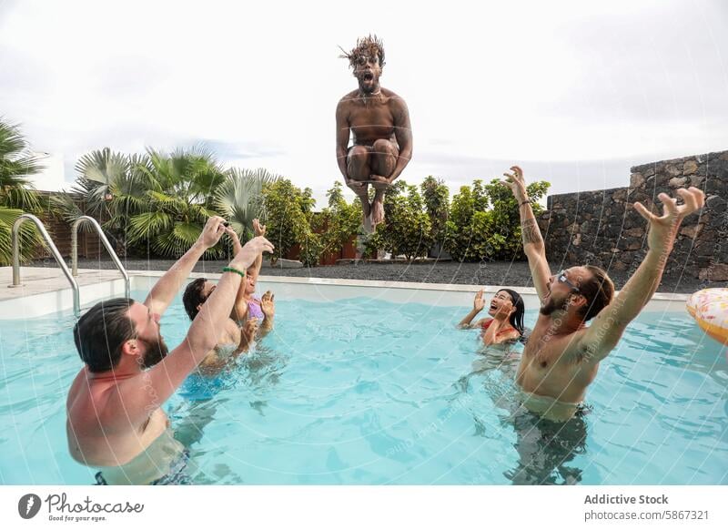 Freunde jubeln, wenn ein Mann ins Schwimmbad springt Sommer Pool heiter springend Schwimmsport Wasser im Freien Spaß Lachen Beckenrand Aufregung Frauen