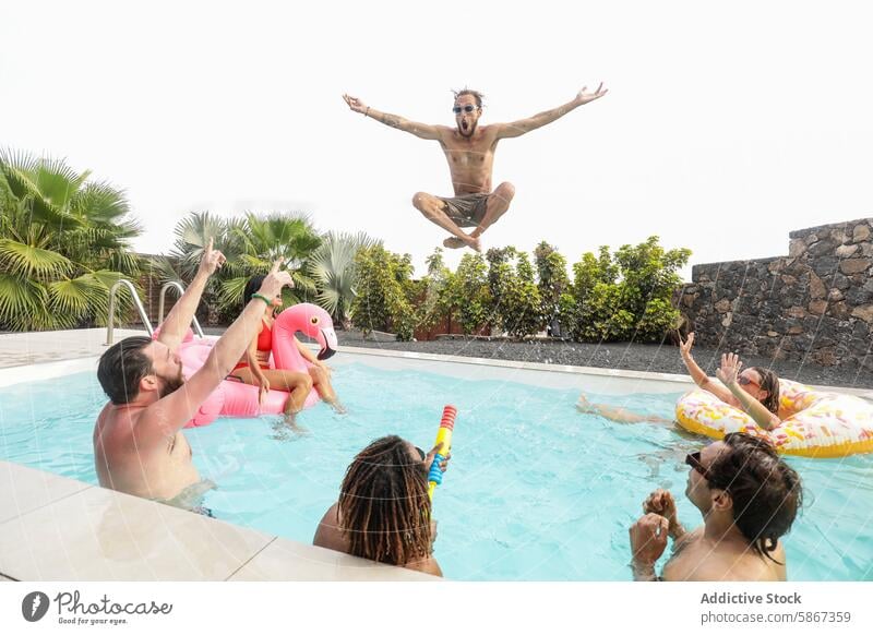 Freunde genießen einen spielerischen Sommertag am Pool Freundschaft Spaß springend vielfältig freudig Party lachen Schwimmsport sich[Akk] entspannen Schwimmer