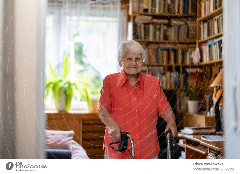 Ältere Frau mit Gehhilfe in ihrem Zimmer stehend Lächeln Glück genießend positiv Freude zufrieden Menschen Senior reif älter heimwärts Haus alt Alterung