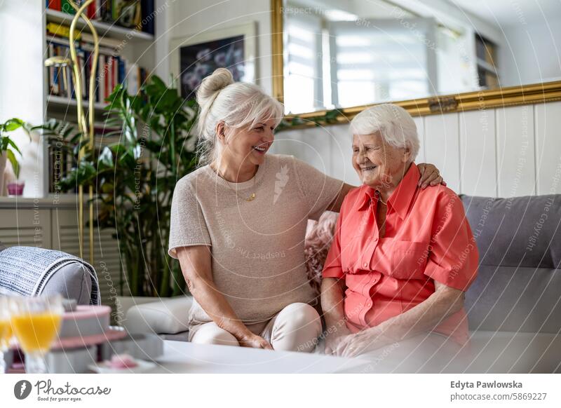 Glückliche ältere Frau mit ihrer erwachsenen Tochter zu Hause Lächeln genießend positiv Freude zufrieden Menschen Senior reif heimwärts alt Alterung