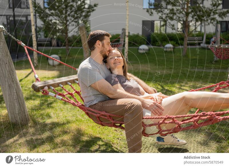 Familie genießt Sommertag in der Hängematte im Park sich[Akk] entspannen im Freien Mutter Vater Paar Liebe Lächeln Umarmen Fröhlichkeit Augen geschlossen