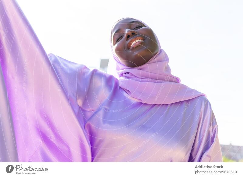 Gelassener Moment im Park mit einer lächelnden Frau im Hidschab Hijab Gelassenheit Lächeln friedlich Sonnenlicht Lifestyle Fröhlichkeit im Freien freudig Sommer