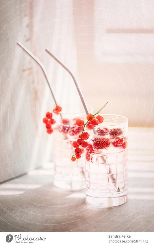 2 Drinks mit Beeren auf dem Tisch - Somer und Sonnenstrahlen Limonade Longdrink Eiswürfel Cocktail Getränk Glas Erfrischungsgetränk Farbfoto lecker Alkohol kalt