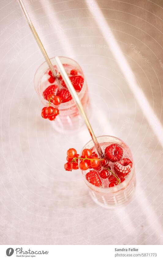 2 Longdrinks mit gefrorenen Früchten und Strohhalm von oben Beeren Getränk Cocktail Glas Farbfoto Erfrischungsgetränk Limonade lecker Eiswürfel Sommer