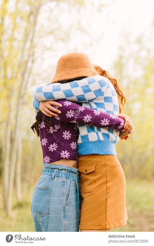 Intime Umarmung zweier anonymer Freunde in einer Waldlandschaft Freundschaft Umarmen Zuneigung Nähe farbenfroh Oberbekleidung Stil pulsierend Wärme Natur