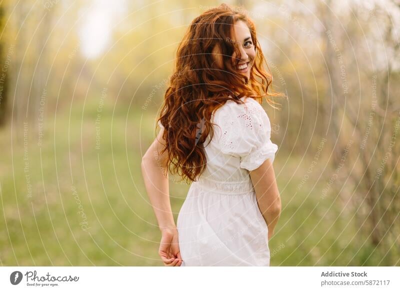 Junge Frau mit roten Haaren genießt die Natur im Wald rote Haare lockig Freude Frühling Lächeln Spaziergang Freiheit Fröhlichkeit Kleid weiß sonnenbeschienen