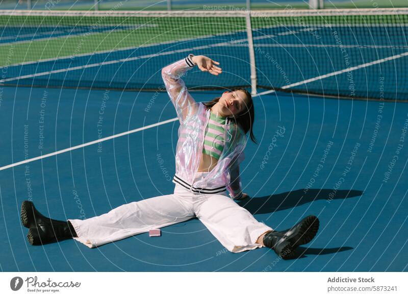 Junge Frau genießt Musik auf einem sonnigen Tennisplatz freudig sorgenfrei jung hören Tanzen Bewegung spielerisch blau Gericht sportlich Freizeit Lifestyle