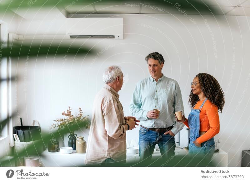 Gemischtrassige Mitarbeiter tauschen in der Pause im Büro Ideen aus Coworking Kaffee Gespräch professionell Kaukasier Afroamerikaner Frau Teamwork