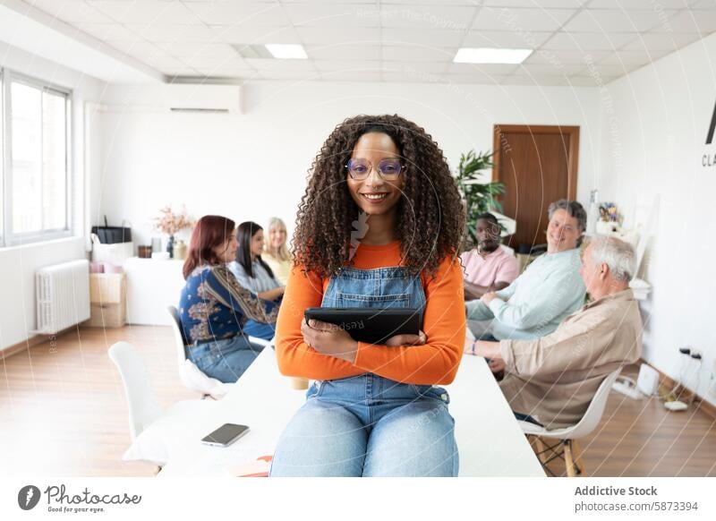 Afroamerikanische Frau mit einem Tablet in einem vielfältigen Coworking Space Technik & Technologie Menschen Afroamerikaner Tablette multiethnisch Business