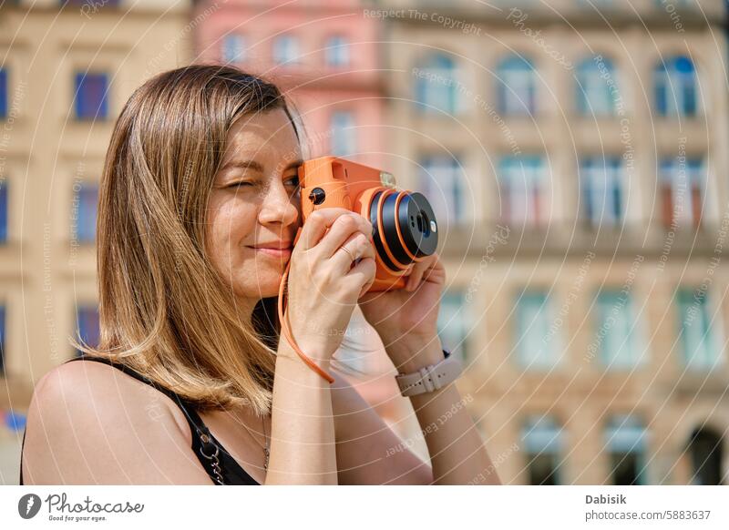 Junge Frau, die in einer europäischen Stadt Fotos macht Fotokamera reisen Tourismus Fotograf europäische Stadt historische Architektur Stadtplatz