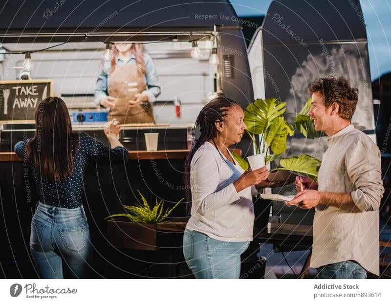 Diverse Freunde bei Essen und Trinken, die sich abends im Park unterhalten Abend sprechen Lebensmittel Lastwagen trinken Imbissbude Speise Zusammensein Mann