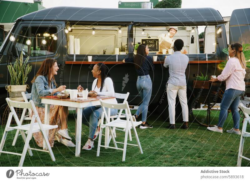 Foodtruck-Kunden plaudern miteinander und mit dem Verkäufer Klient Lebensmittel Lastwagen sprechen Anbieter Hof Mittagessen Zusammensein Glück Wochenende reden