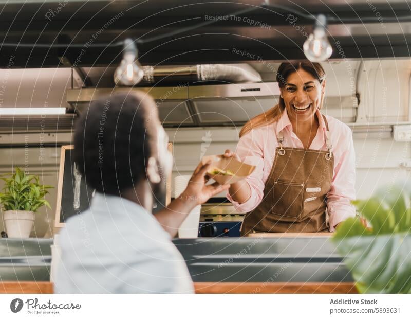 Glücklicher hispanischer Verkäufer, der einem schwarzen Kunden Salat zum Mitnehmen gibt Klient Imbissbude Salatbeilage Lächeln Arbeit Lebensmittel Lastwagen