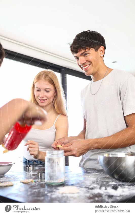 Geschwister kochen gemeinsam in einer modernen Küche Essen zubereiten Zusammenarbeit Mahlzeit backen Lachen Freude Geschwisterkind Familie Zusammensein lässig