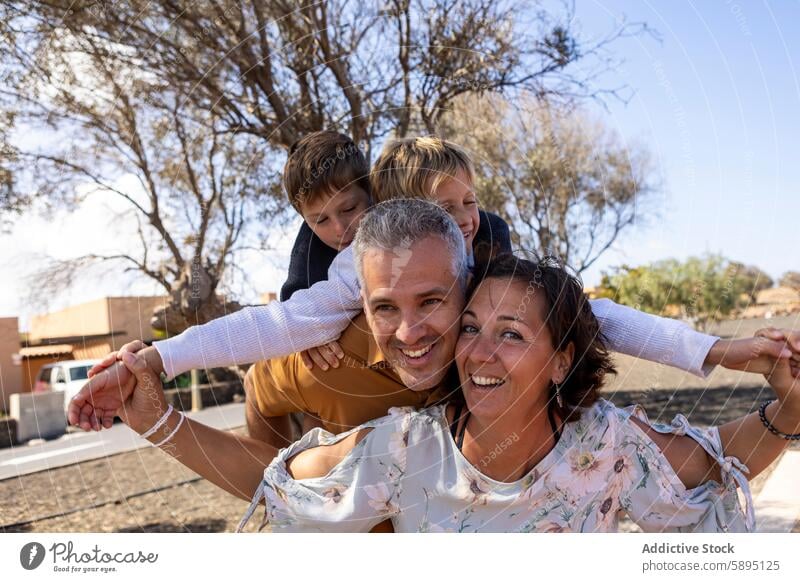 Eine vierköpfige Familie genießt einen sonnigen Tag im Park spielerisch Vater Mutter Söhne Herbst Geschwister Bruder Lächeln Bonden Freizeit Aktivität Lifestyle