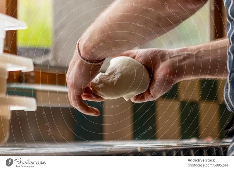 Pizzabäcker knetet Teig auf dem Küchentisch Teigwaren kneten Dehnung Hand Küchenchef Textur Prozess backen Essen zubereiten Kunstgewerbler kulinarisch