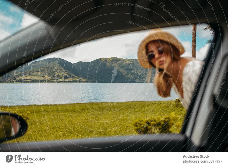 Frau genießt die Aussicht aus dem Auto auf Sao Miguel, Azoren. São Miguel PKW Ansicht Landschaft See reisen Natur verdunkelt Strohhut Sonnenbrille Freizeit