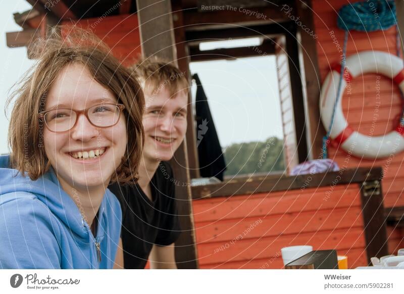 Ein Teenage-Mädchen und ihr Freund sitzen auf einem Floß und freuen sich über die Fahrt Ferien Wochenende Ausflug Spaß Junge Schwester Bruder Freundin