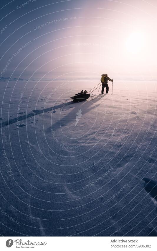 Forscher ziehen Schlitten in verschneiter Landschaft bei Sonnenuntergang Entdecker Schnee kalt Berge u. Gebirge Expedition polar Natur im Freien Abenteuer