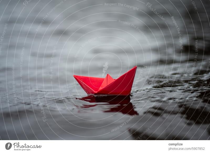 Rotes Papierschiff in großen Wellen im Sturm auf einem See papierschiff rot rötlich gefahr wellen sturm see meer wellig stürmig business alleine freedom frei