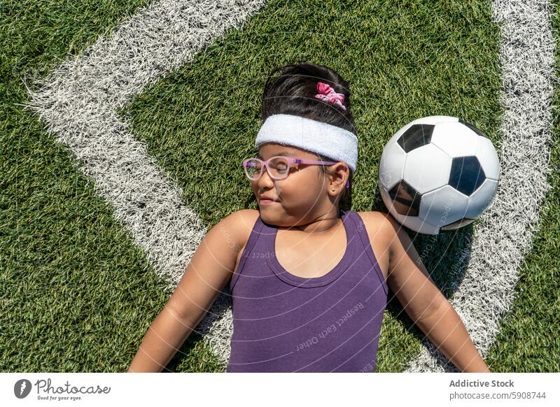 Junges Mädchen entspannt sich neben einem Fußball auf einem Feld Sport Ball Gras spielen sich[Akk] entspannen freudig Fitness Freizeit Aktivität Erholung