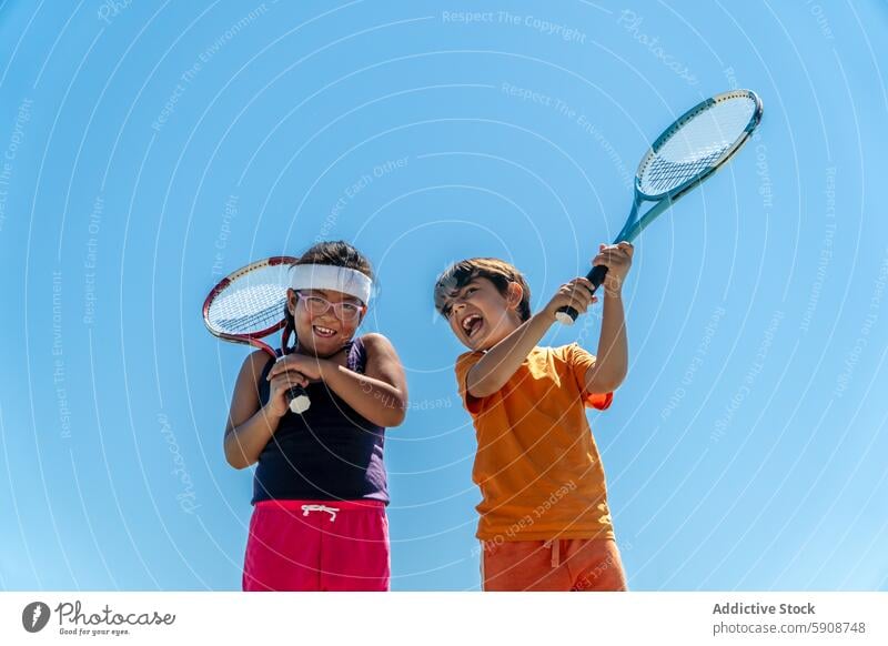 Fröhliche multiethnische Kinder genießen ein Tennisspiel im Freien Freundschaft Sport Remmidemmi Spiel spielen Freude Lachen Glück Aufregung Sommer Junge