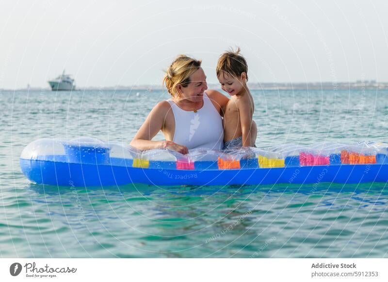 Mutter und Sohn genießen einen sonnigen Tag an einem italienischen Strand Italienisch aufblasbar Wasser fliegend Sommer Freude spielerisch MEER Familie Urlaub