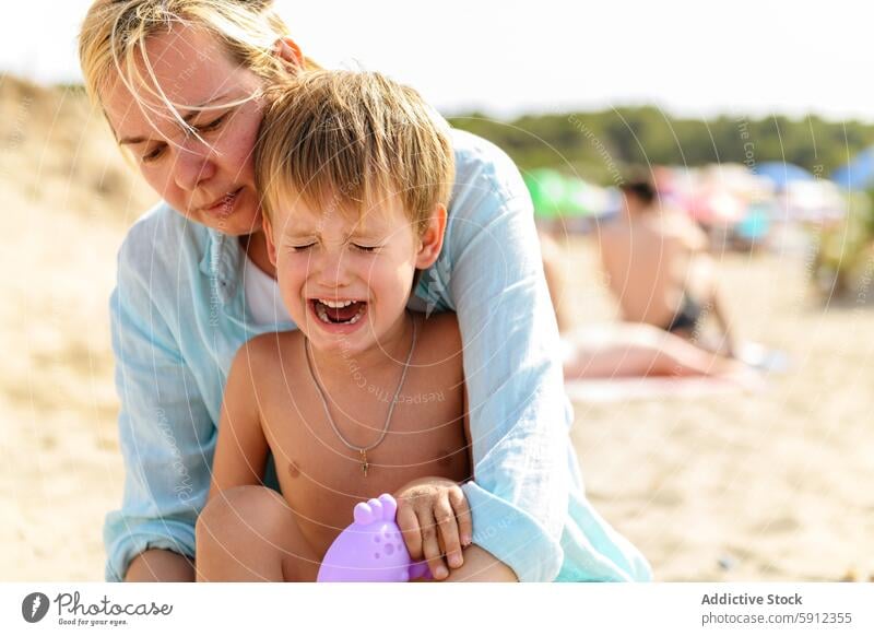 Mutter tröstet Sohn während eines Strandtages in Italien Weinen Komfort MEER Sommer Sand Unzufriedenheit Familie Urlaub reisen Tag sonnig Kind Frau Geplätscher