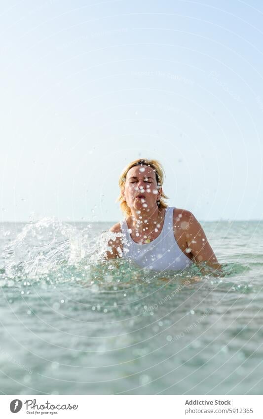 Frau beim Planschen im Wasser am italienischen Strand Italien MEER Schwimmsport platschen Sommer Urlaub Feiertag Badeanzug weiß hell Sonnenlicht übersichtlich