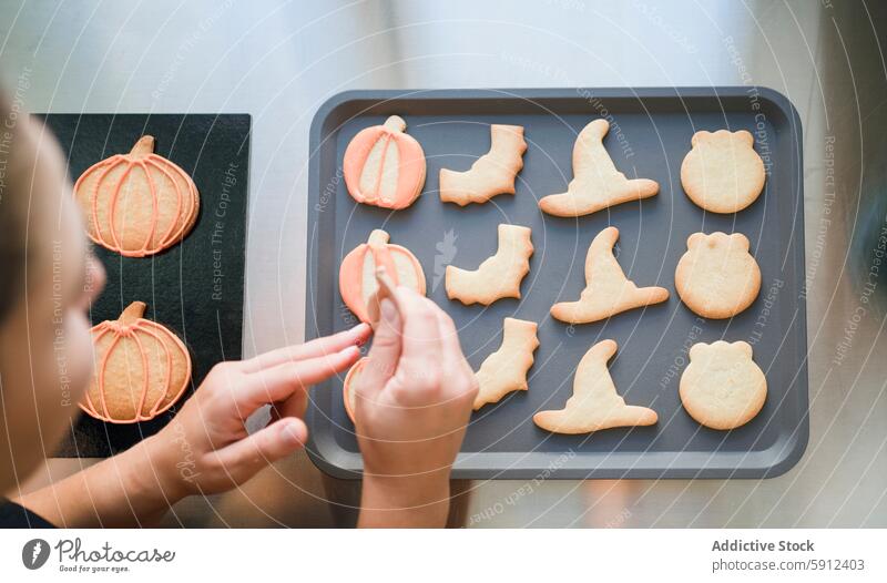 Dekorieren von selbstgebackenen Halloween-Keksen auf einem Backblech Dekoration & Verzierung Tablett Kürbis Hexenhut selbstgemacht Küche Feiertag Leckerbissen