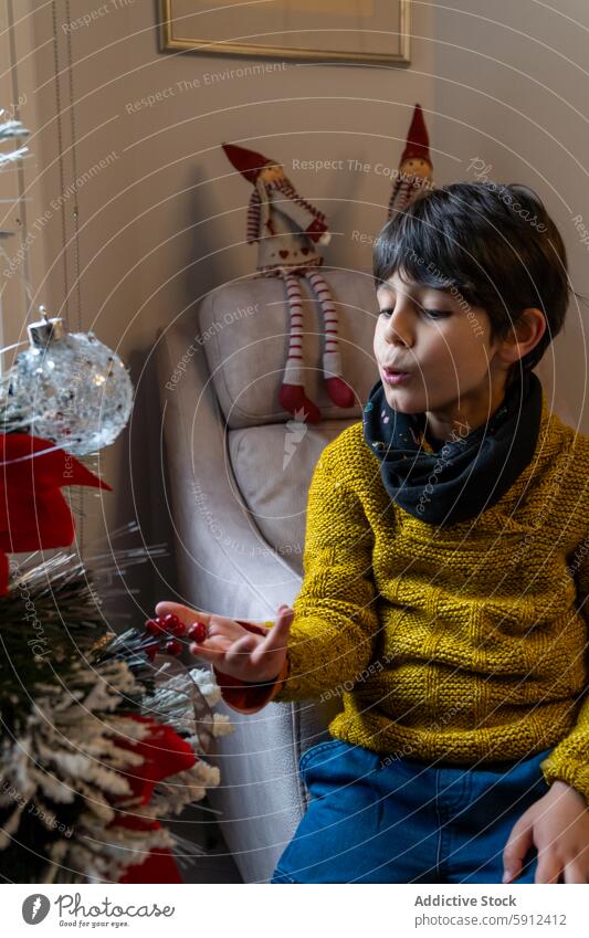 Junge im gelben Pullover beim Schmücken des Weihnachtsbaums Dekoration & Verzierung Feiertag festlich Weihnachten gemütlich feiern Freude im Innenbereich Saison