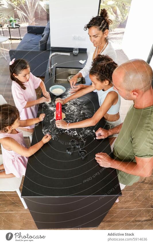 Familie bei der gemeinsamen Zubereitung von Keksen in einer modernen Küche backen Cookies heimwärts Kinder Erwachsene Nudelholz Ausstechform Mehl