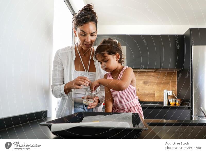 Mutter und Tochter backen Kekse in der Küche Frau Mädchen Kind bestäuben Teigwaren Tablett Essen zubereiten Familie Bonden heimwärts im Innenbereich Rezept