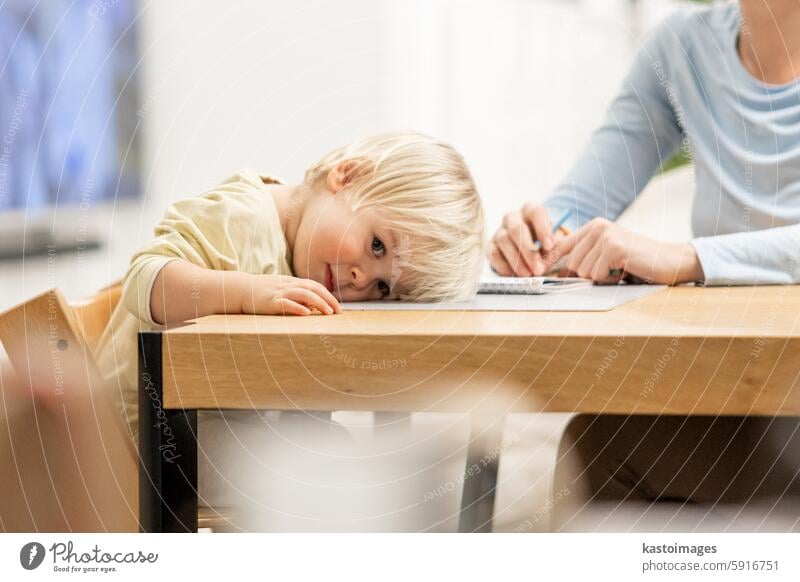 Caring junge kaukasische Mutter und kleinen Sohn Zeichnung Malerei in Notebook zu Hause zusammen. Liebevolle Mutter oder Kindermädchen mit Spaß am Lernen und Spielen mit ihrem kleinen 1,5 Jahre alten Säugling Baby Junge Kind.