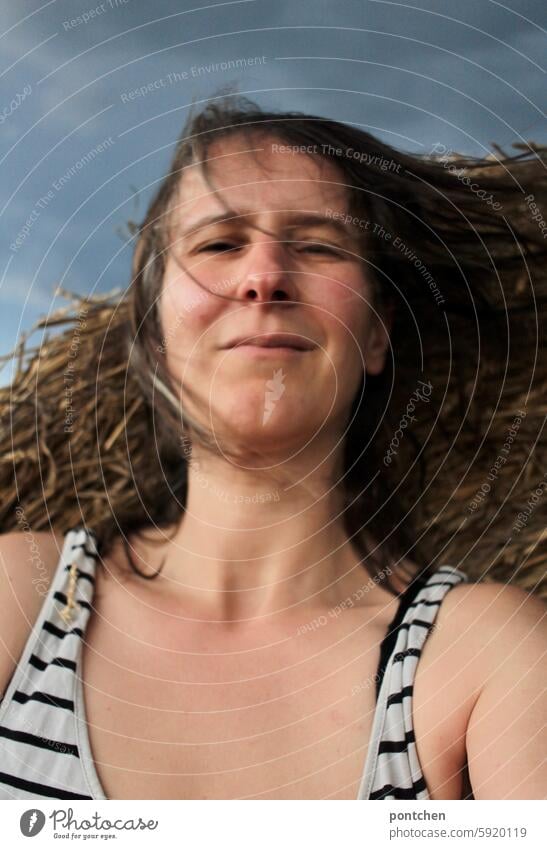 ein gewitter zieht auf. frau vor strohballen und dunklen wolken dunkle wolken windig stürmisch besorgt landwirtschaft wetterumschwung veränderung Himmel