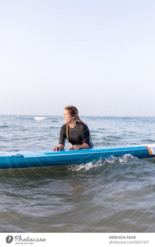 Frau schwimmt auf Paddleboard im Meer Surfer Paddelbrett Zusatzplatine SUP MEER Schwimmer schwimmen Surfbrett Sommer Holzplatte Wasser Lügen Badebekleidung