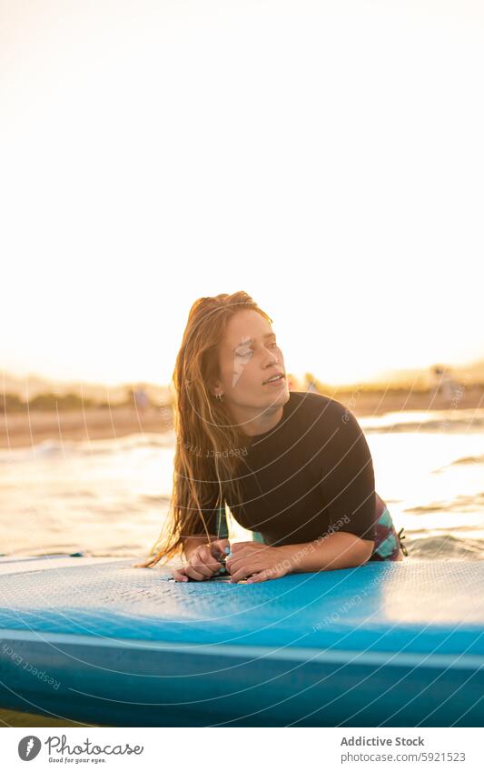 Frau schwimmt auf Paddleboard im Meer Surfer Paddelbrett Zusatzplatine SUP MEER Schwimmer schwimmen Sonnenuntergang Surfbrett Sommer Holzplatte Wasser Lügen