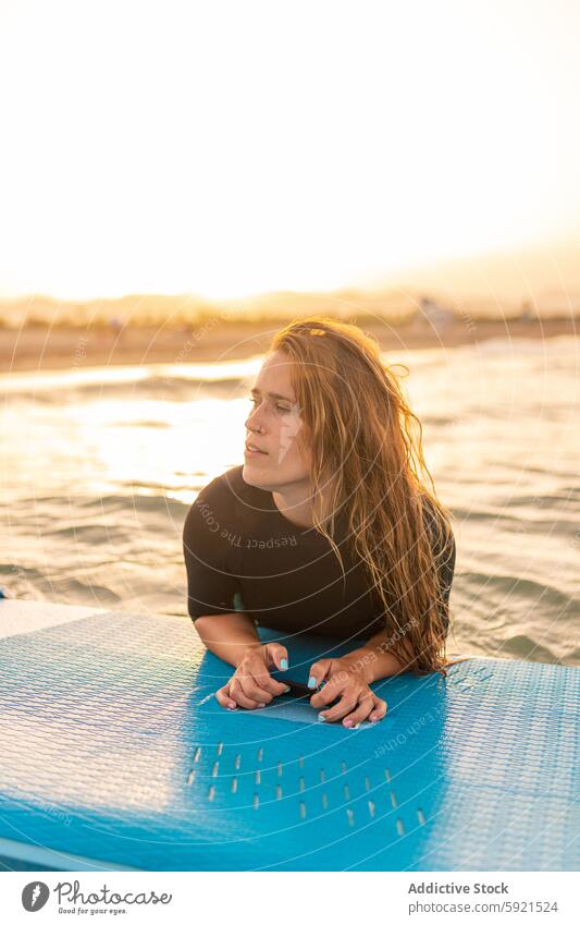 Frau schwimmt auf Paddleboard im Meer Surfer Paddelbrett Zusatzplatine SUP MEER Schwimmer schwimmen Sonnenuntergang Surfbrett Sommer Holzplatte Wasser Lügen