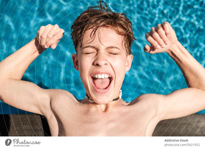 Aufgeregter Junge beim Muskeltraining am Pool an einem sonnigen Tag Kind Aufregung Schwimmsport Wasser im Freien Sommer Fröhlichkeit nass Behaarung Panzer