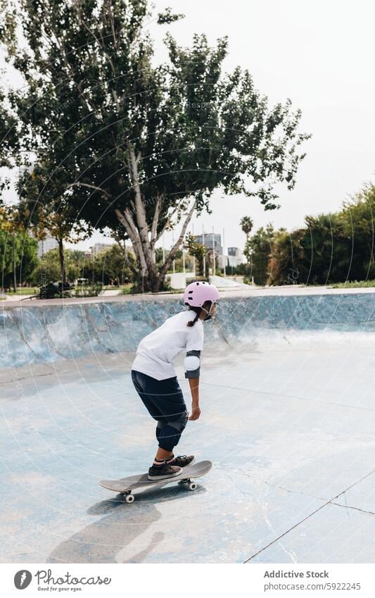 Junge Person mit Skateboard im Skatepark behüten Skateplatz Mitfahrgelegenheit Training Hobby Skater Schutzhelm extrem Bewegung Schlittschuh Energie Rampe Pool