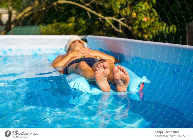 Ein Mann liegt auf einer Luftmatratze in einem Pool. Ferien & Urlaub & Reisen Erholung Sommer Wasser Schwimmen & Baden Sommerurlaub Erfrischung Außenaufnahme