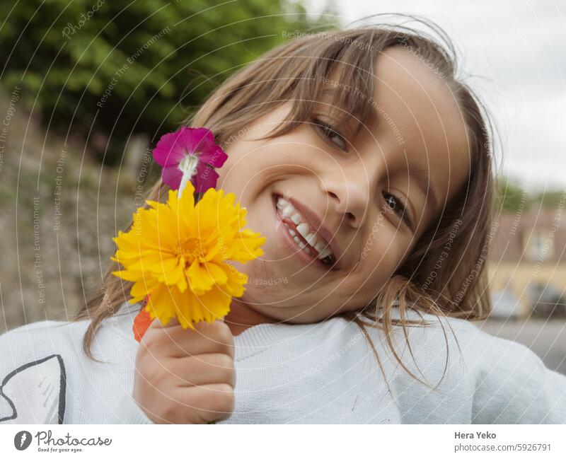 Porträt eines lächelnden Mädchens mit einem Blumenstrauß Lächeln Fröhlichkeit gelb purpur Kindheit schön Glück jung hübsch Lifestyle Schönheit Gesicht Freude