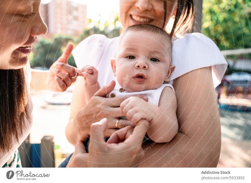 Glückliches Baby, das sich mit einem liebenden lesbischen Paar in sonniger Umgebung bindet Bonden kolumbianisch Liebe im Freien Familie Nahaufnahme Lächeln